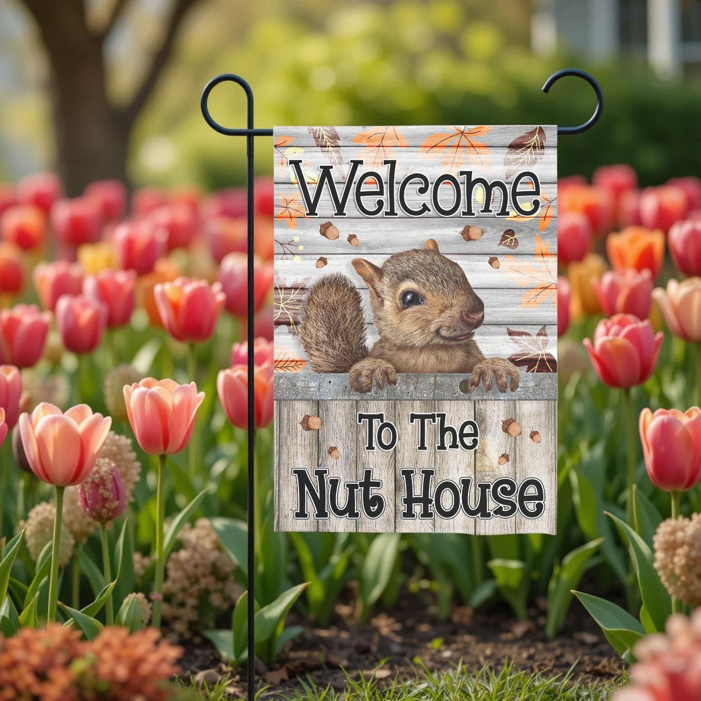A garden flag with a squirrel on it, displaying the text "Welcome to the Nut House".