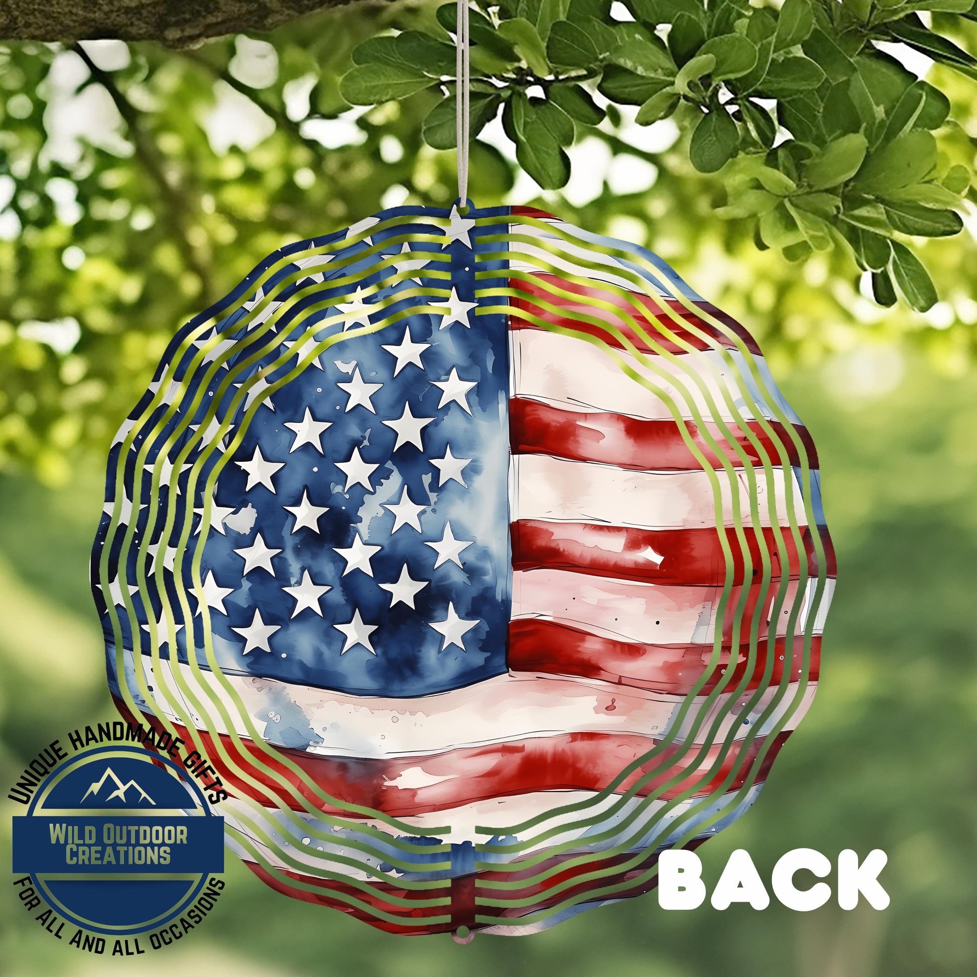 a patriotic American flag-themed windmill decoration hanging from a tree branch.